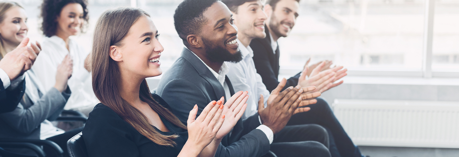 Group of employees sitting down clapping